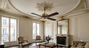 Ventilateur de plafond silencieux en laiton brossé suspendu sous une rosetta en plâtre dans un appartement haussmannien classique